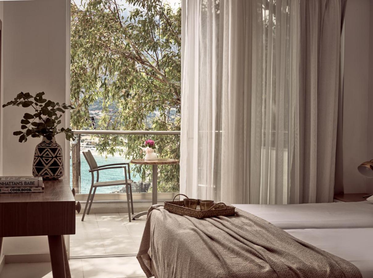 een slaapkamer met een bed en een groot raam bij Troulis Apart-Hotel in Balíon