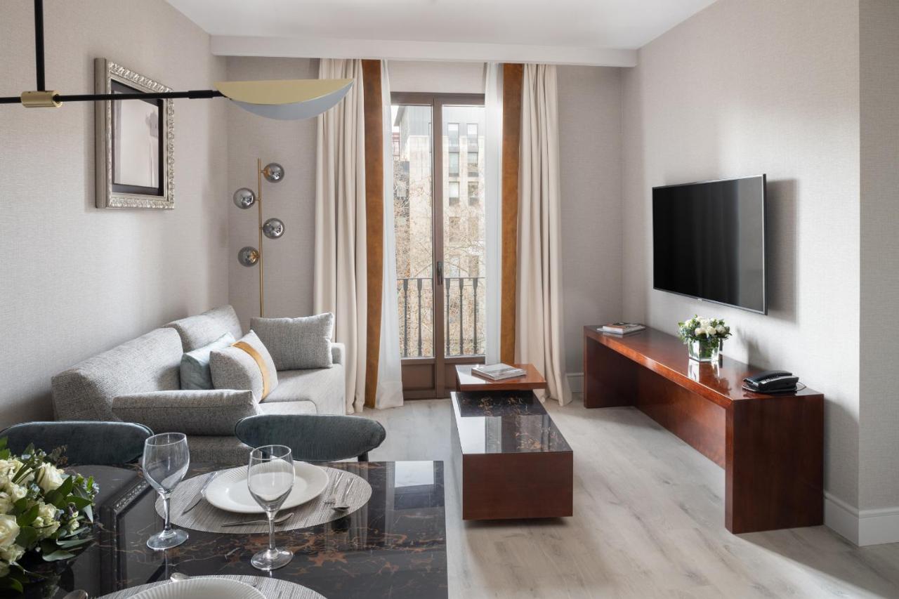 een woonkamer met een bank en een tv bij Suites Center Barcelona in Barcelona