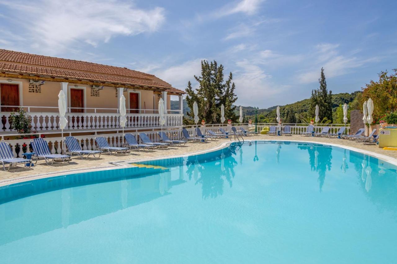 een groot zwembad met ligstoelen en een gebouw bij Corfu Panorama by Estia in Moraitika