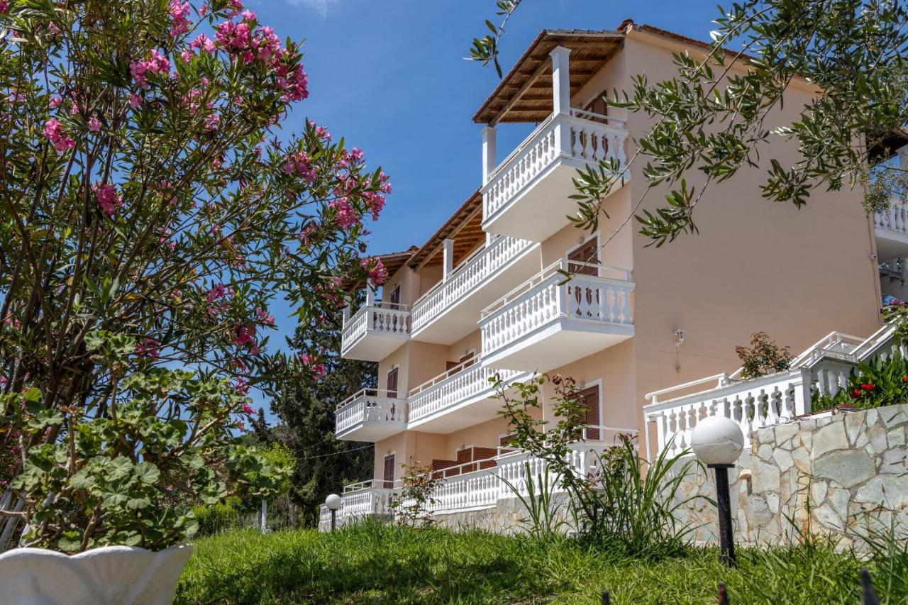een gebouw met witte balkons en roze bloemen bij Corfu Panorama by Estia in Moraitika