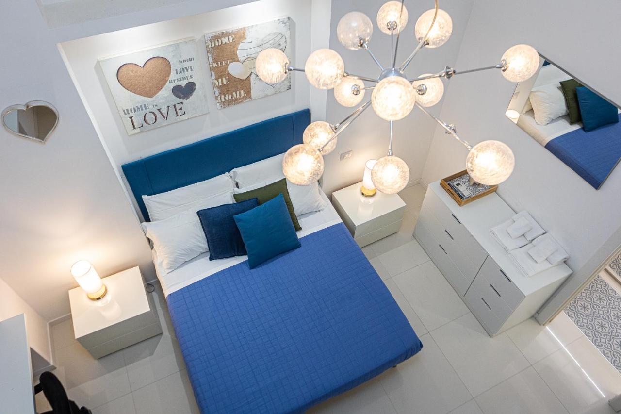 een slaapkamer met een blauw bed en een kroonluchter bij Residenza Santi ai Monti in Rome