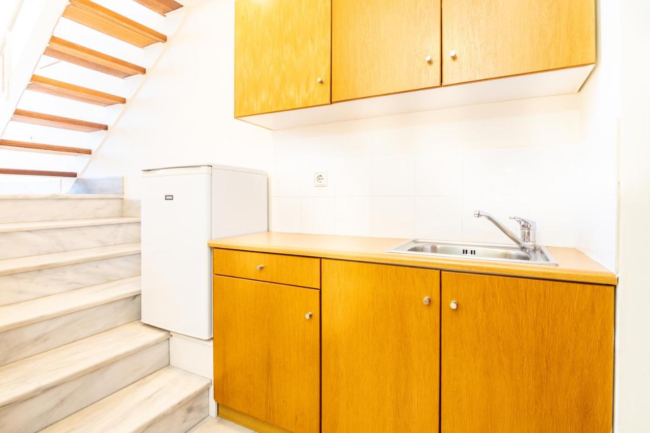 een keuken met houten kasten en een trap bij Orestis Hotel Sea View Apartments in Stalós
