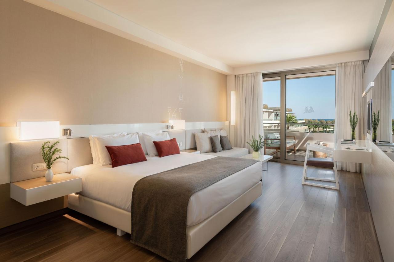 een grote slaapkamer met een groot bed en een balkon bij Avra Imperial Hotel in Kolymvari