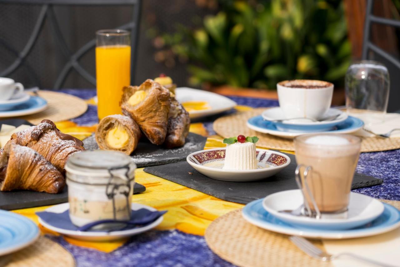 een tafel met borden met eten en kopjes koffie en gebak bij Hotel Murmann in Maratea