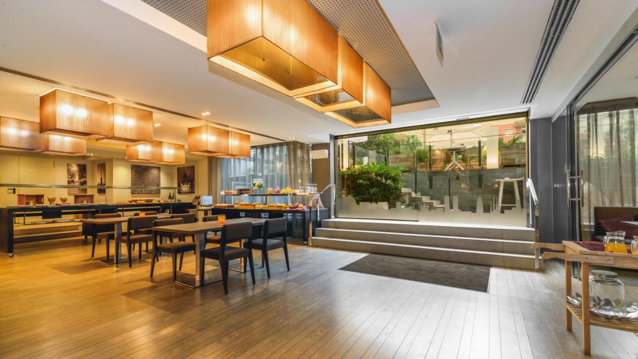 een restaurant met tafels en stoelen in een ruimte bij Grums Hotel&Spa in Barcelona