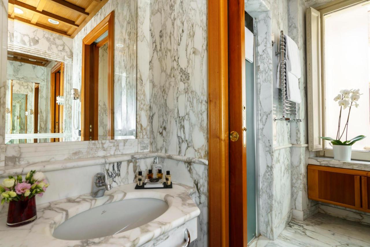 een badkamer met een wastafel en een spiegel bij Hotel Valadier in Rome
