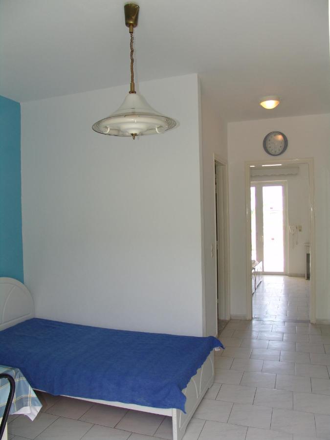 een slaapkamer met een blauw bed en een klok aan de muur bij Kontessa Apartments in Kefalos +47 foto's