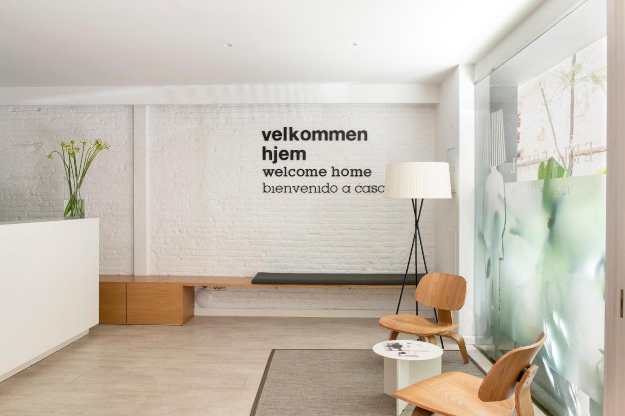 een woonkamer met een muur waarop een welkomstbord hangt bij Eric Vökel Boutique Apartments - BCN Suites in Barcelona