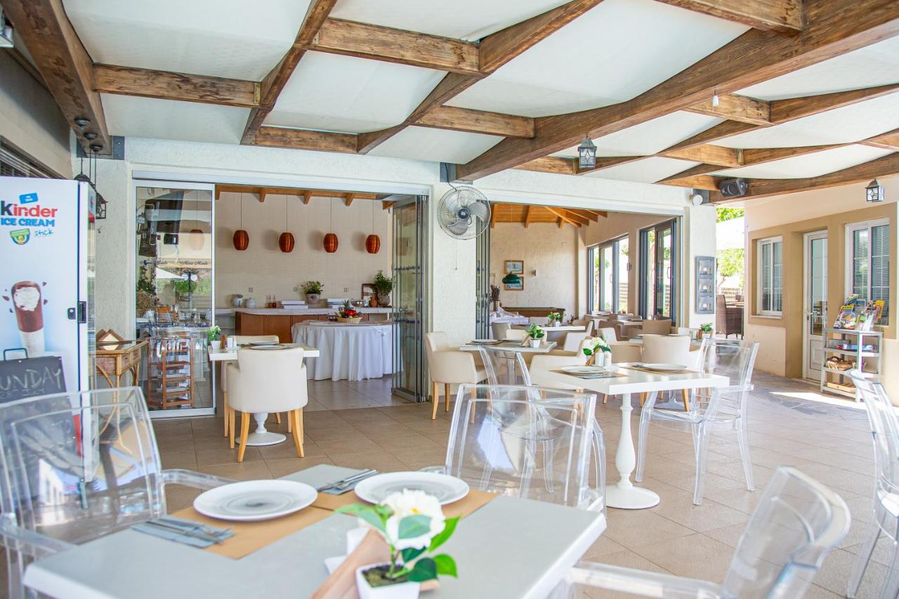 een restaurant met tafels en stoelen in een ruimte bij Villa Mare Monte ApartHotel in Malia