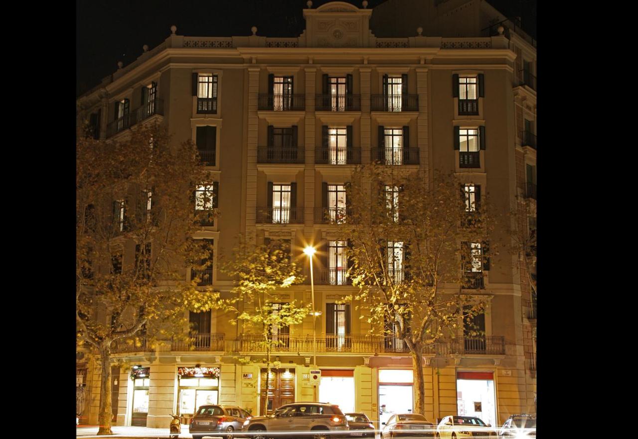 een groot gebouw met auto's ervoor geparkeerd bij MH Apartments Suites in Barcelona