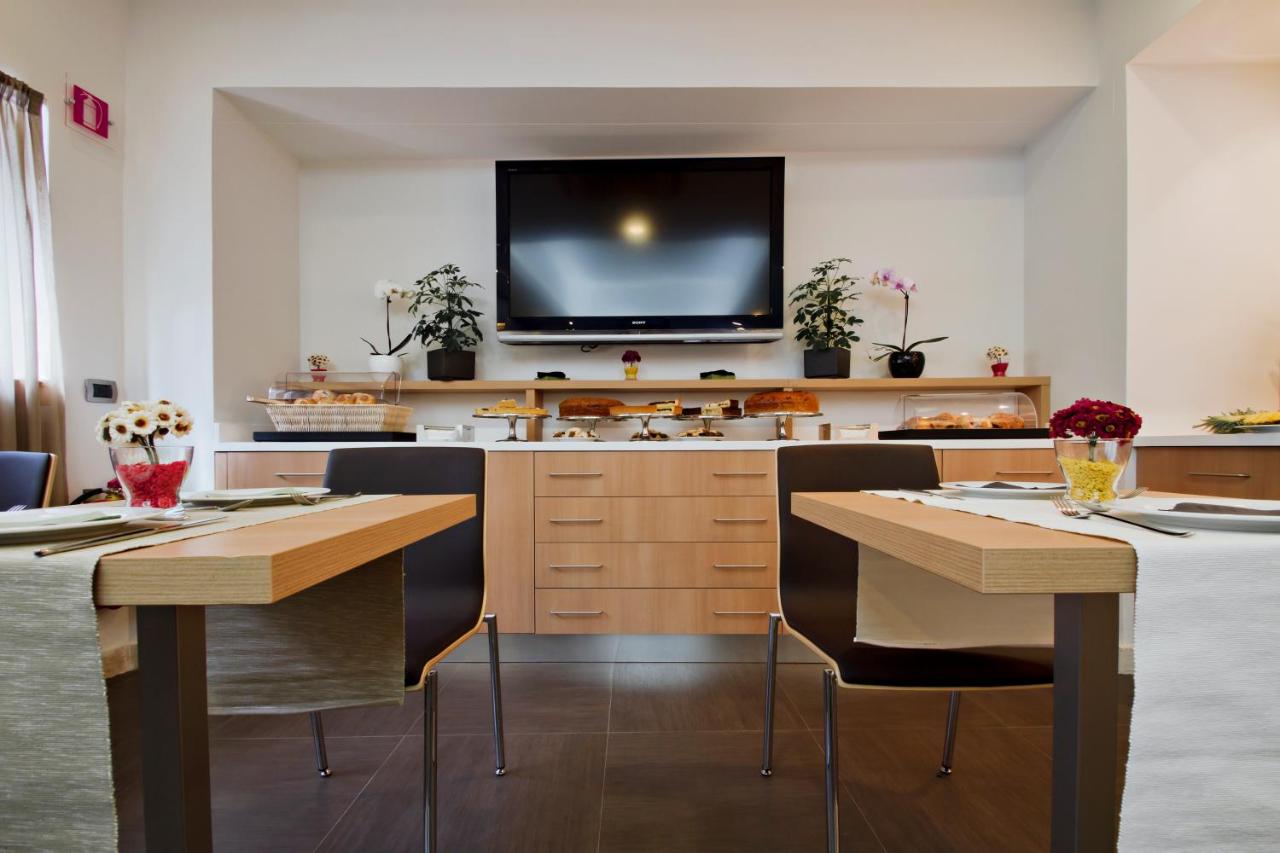 een keuken met twee tafels en een tv aan de muur bij Hotel Gravina San Pietro in Rome