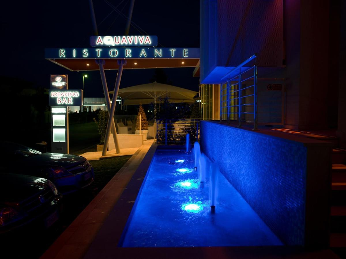 Een nachtelijk uitzicht op een restaurant met blauwe verlichting. bij Breaking Business Hotel in Mosciano SantʼAngelo