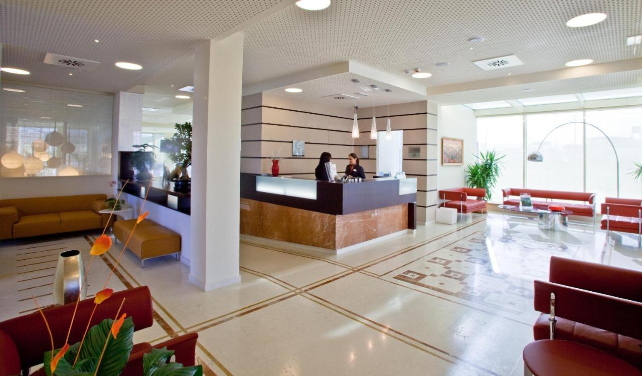 De lobby van een restaurant met een toonbank en stoelen. bij Breaking Business Hotel in Mosciano SantʼAngelo