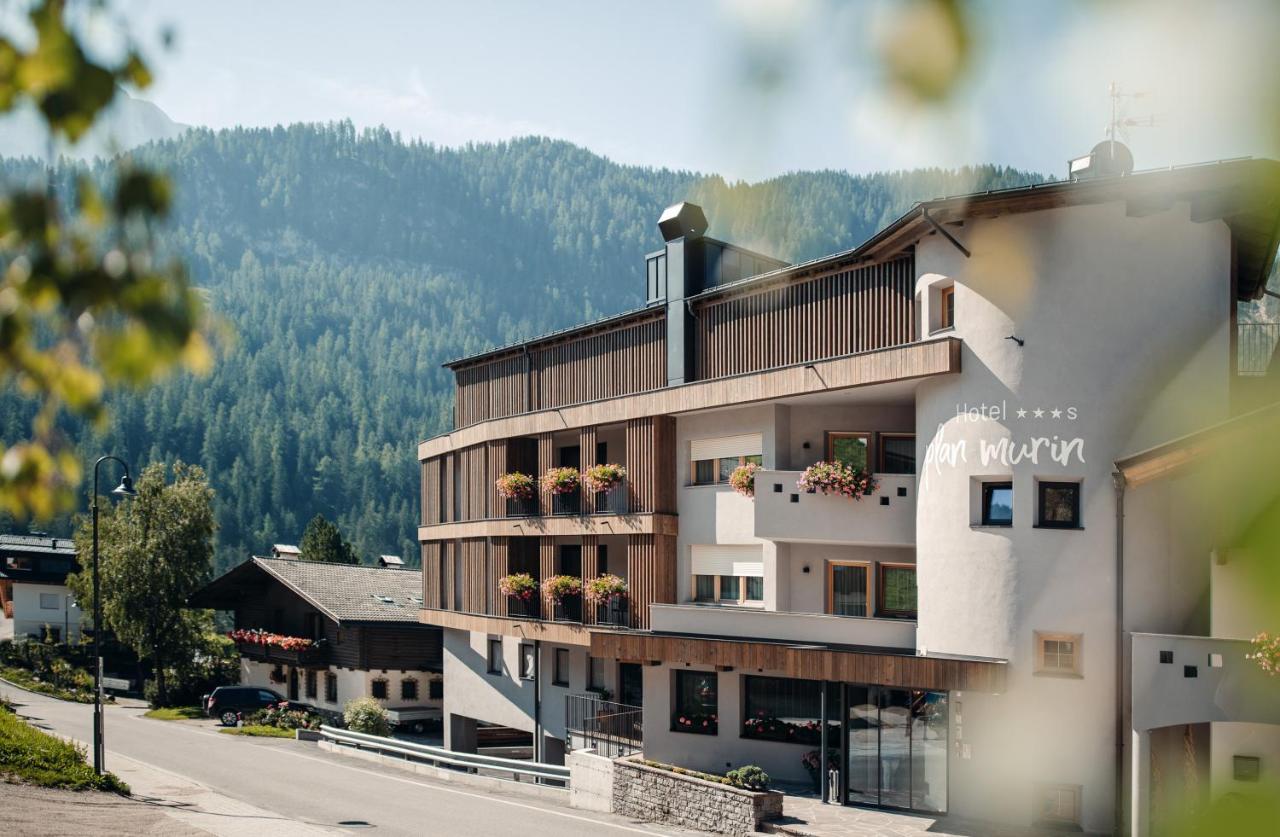 een gebouw met een balkon versierd met bloemen bij Plan Murin - Authentic Dolomites Hotel in La Valle
