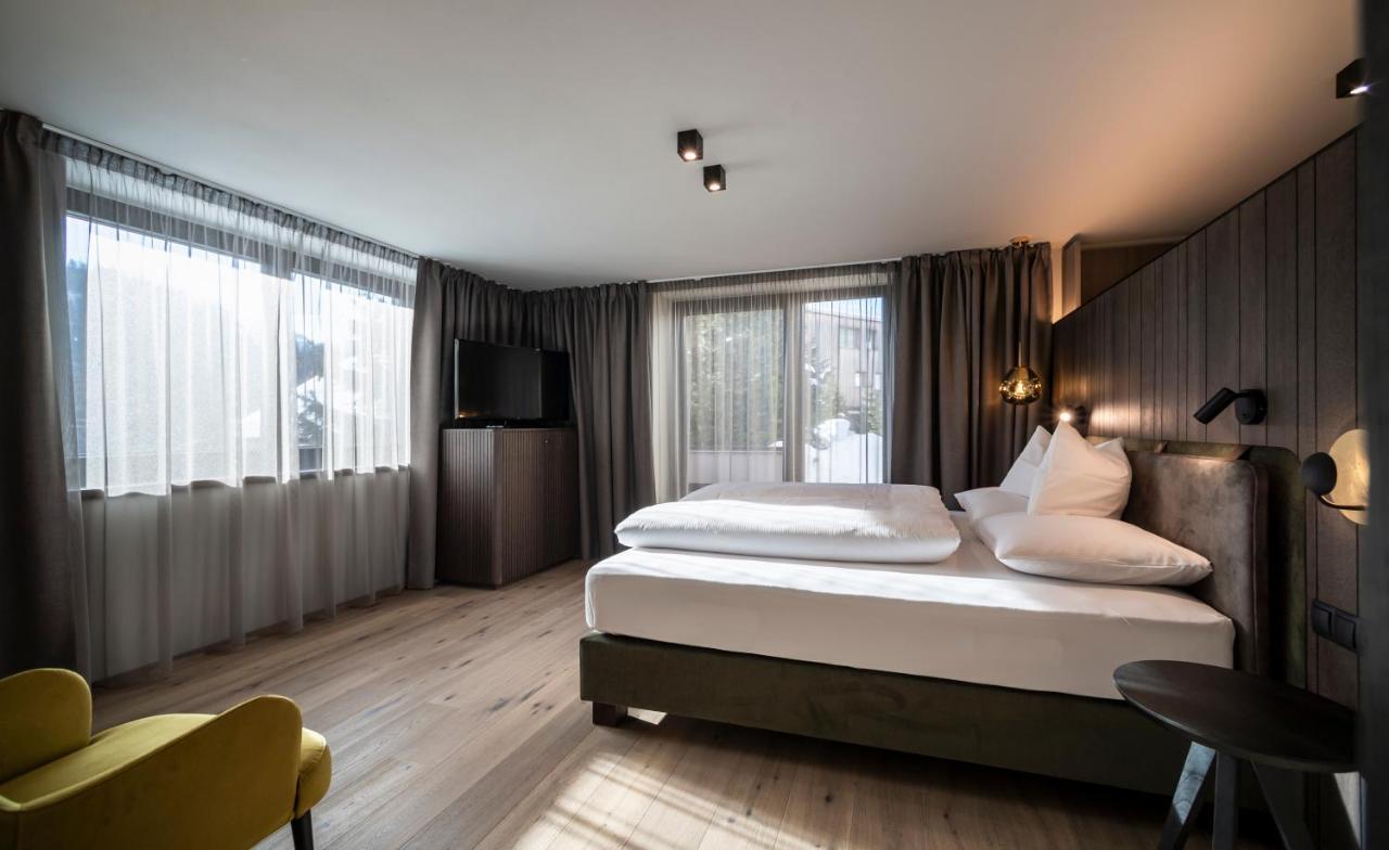 een hotelkamer met twee bedden en een televisie bij Plan Murin - Authentic Dolomites Hotel in La Valle +83 foto's