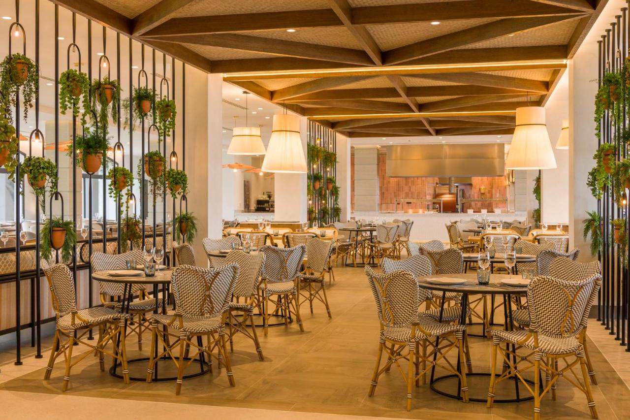 een restaurant met tafels en stoelen in een ruimte bij Ilunion Islantilla in Islantilla