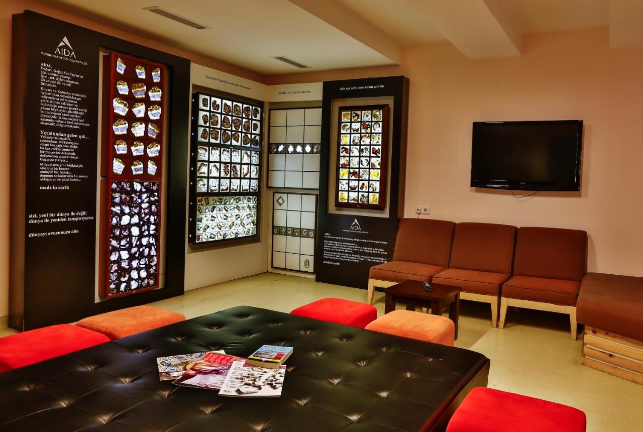 een wachtkamer met een tafel, stoelen en een tv bij Han Hotel Istanbul in Istanbul