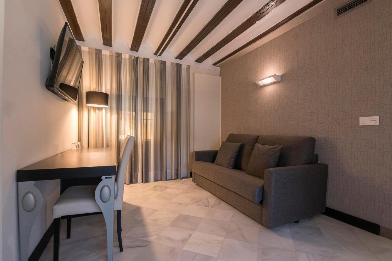 een woonkamer met een bank en een tafel bij Hotel Palacio Marqués de Arizón in Sanlúcar de Barrameda