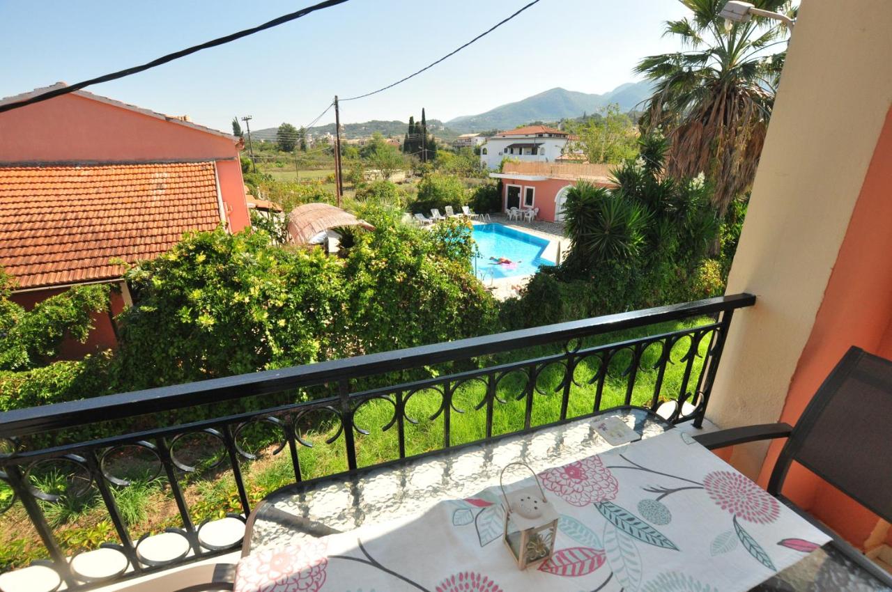 een balkon met een tafel en uitzicht op een zwembad bij Elena Apartments Corfu in Acharavi +33 foto's