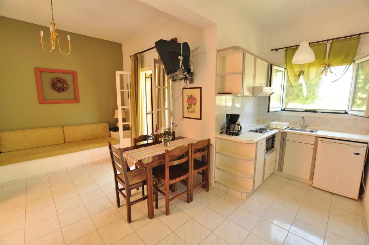 een keuken met een tafel en een bank in een kamer bij Elena Apartments Corfu in Acharavi