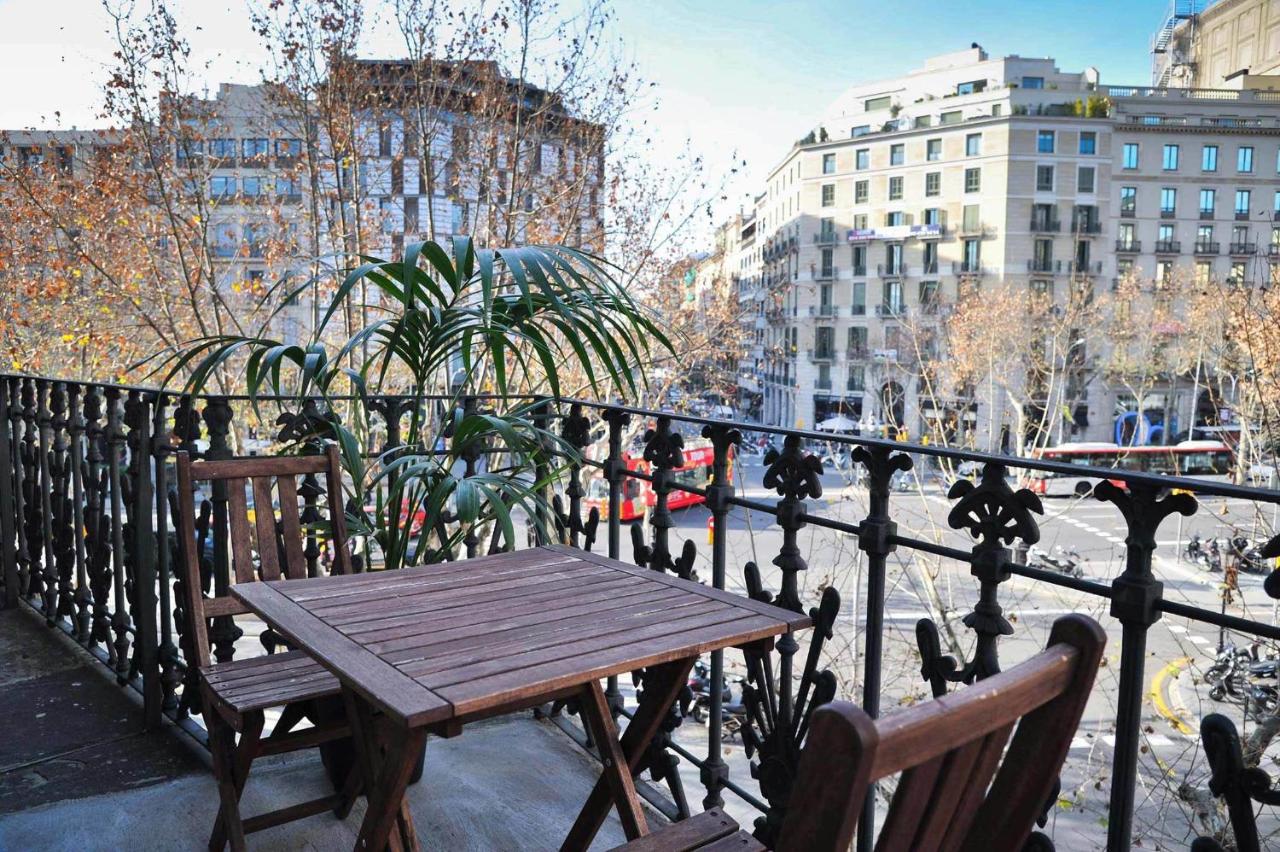 een houten tafel op een balkon met uitzicht op de stad bij Hotel Paseo de Gracia in Barcelona