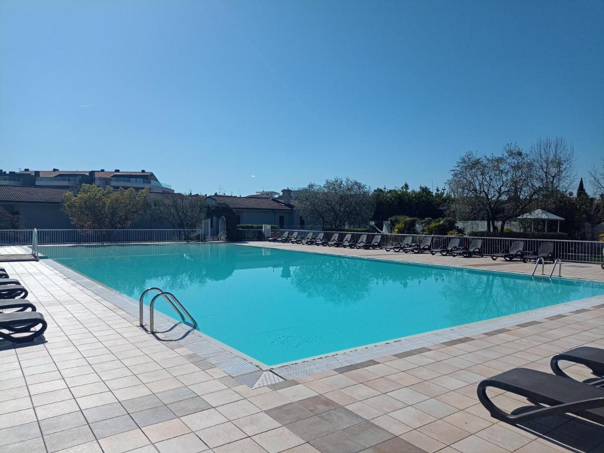 een groot zwembad met ligstoelen in een resort bij Hotel Villa Maria in Desenzano del Garda +16 foto's