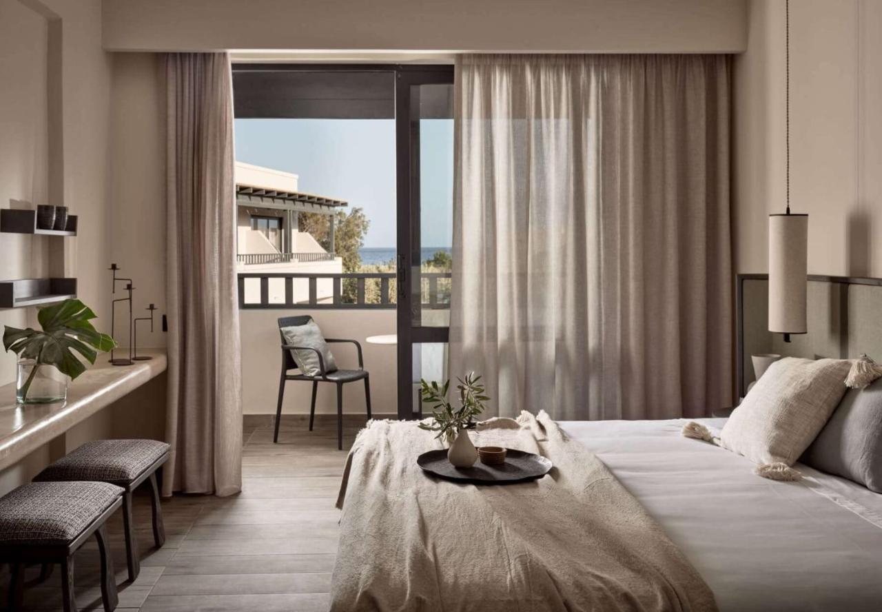 een hotelkamer met een bed en een balkon bij Numo Ierapetra Beach Resort Crete, Adults only, Curio Collection Hilton in 