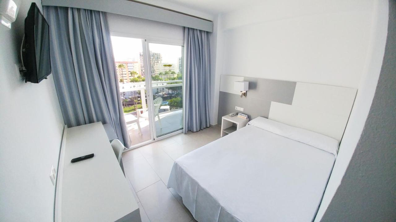 een hotelkamer met een bed en een groot raam bij Globales Los Patos Park in Benalmádena