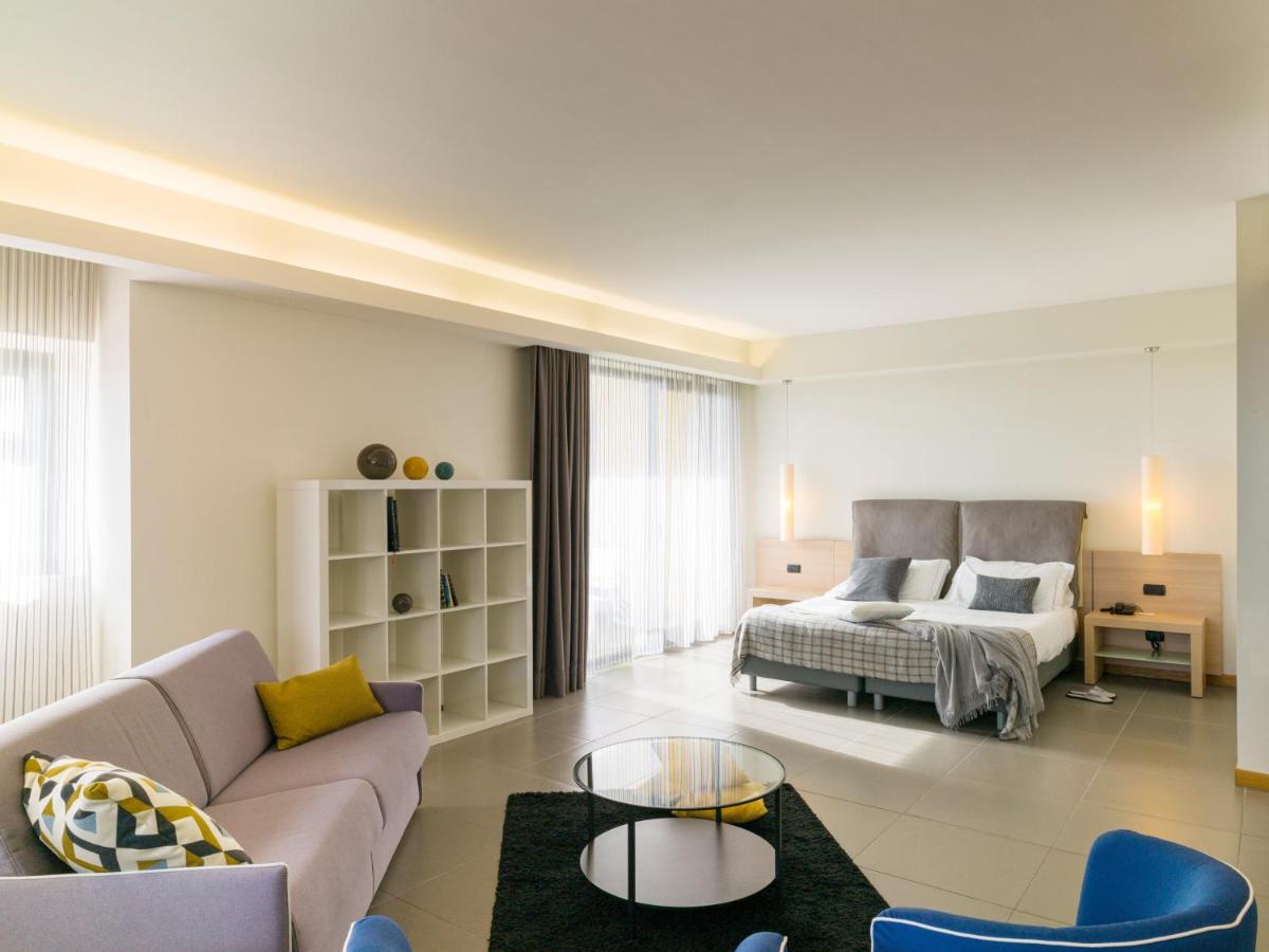 een woonkamer met een bank en een bed bij Esperia Palace Hotel & Resort Spa in Zafferana Etnea