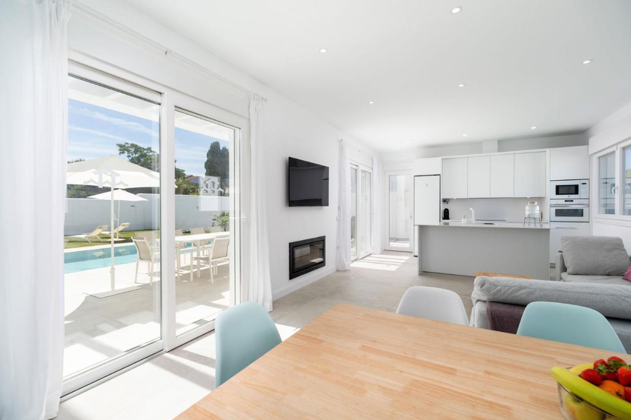 een woonkamer met een tafel en een keuken met uitzicht bij Elena Sea Villa in Poblado de Sancti Petri