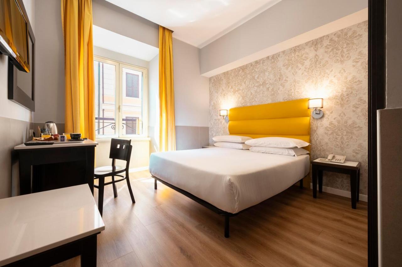 een slaapkamer met een bed met een geel hoofdeinde bij Hotel Virgilio in Rome +56 foto's