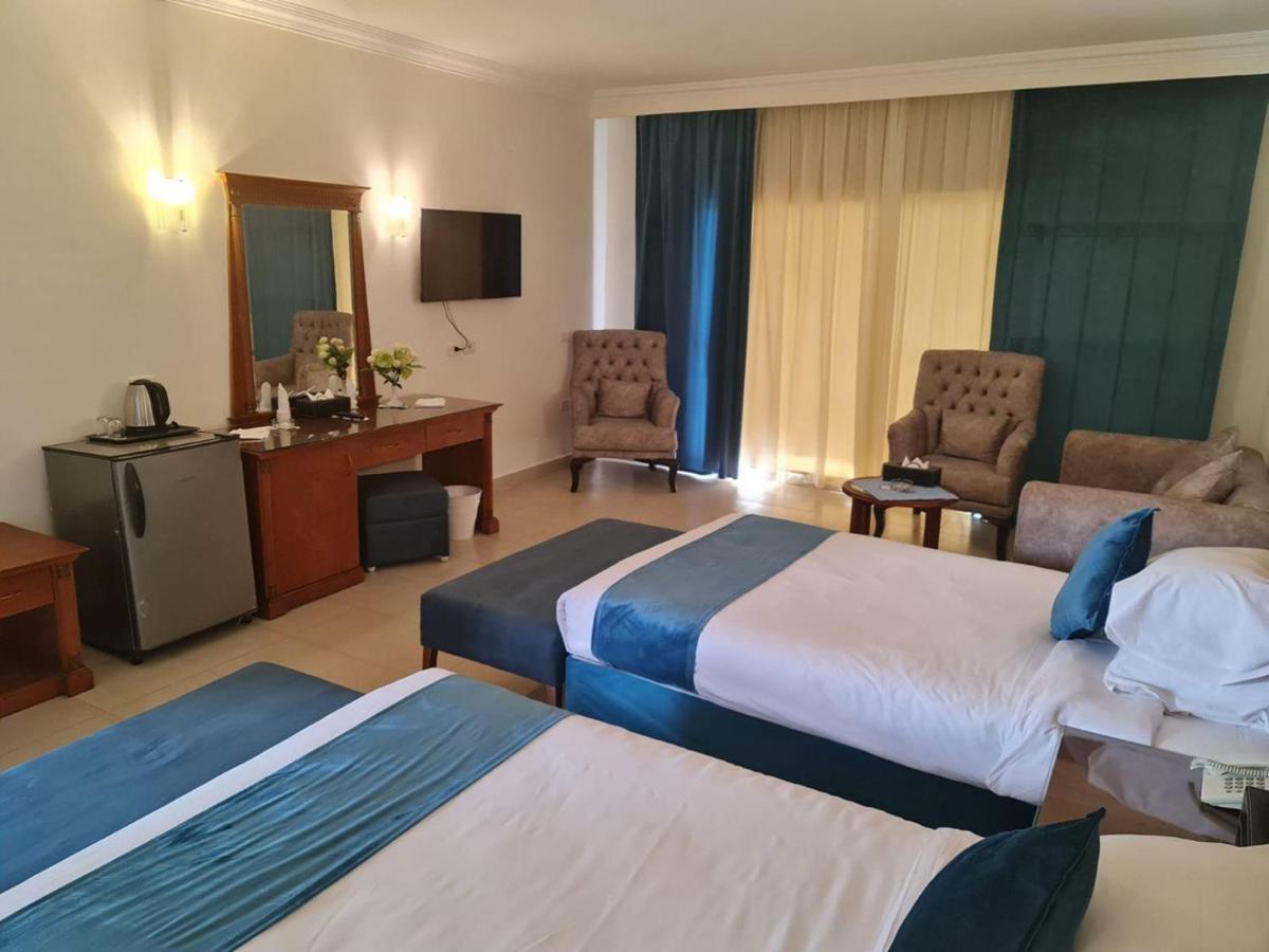een hotelkamer met twee bedden en een televisie bij Sharm Bride Resort Aqua & SPA in Sharm El Sheikh