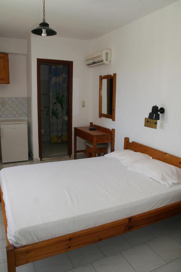 een slaapkamer met een groot wit bed in een kamer bij Andavis Hotel in Kardamaina