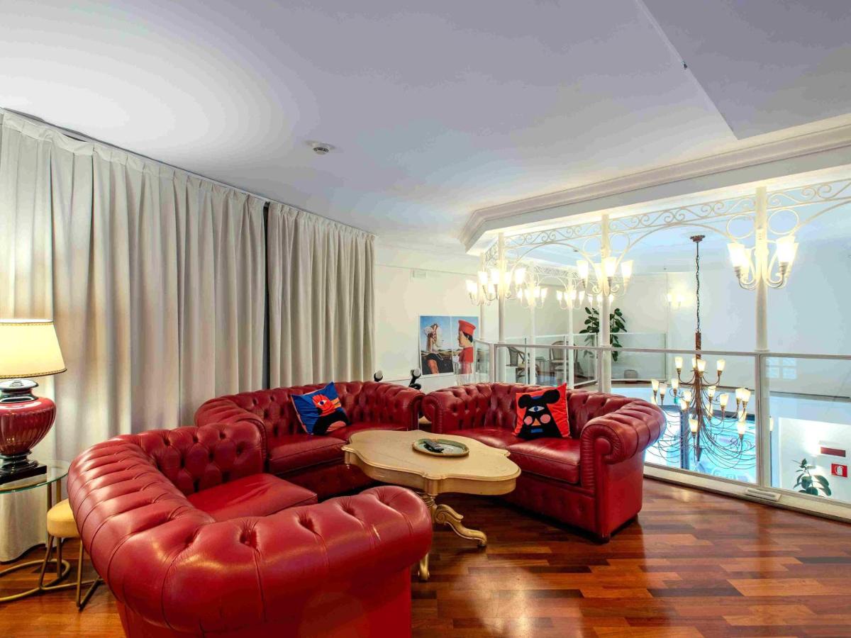 een woonkamer met twee rode banken en een tafel bij B&B Hotel Firenze Laurus Al Duomo in Florence