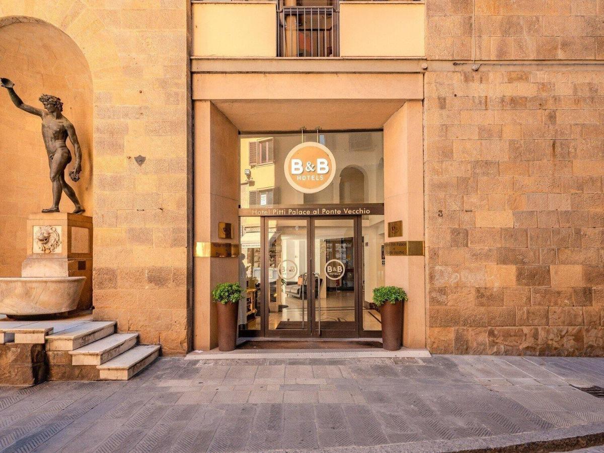 een ingang van een gebouw met een standbeeld ervoor bij B&B Hotel Firenze Pitti Palace al Ponte Vecchio in Florence