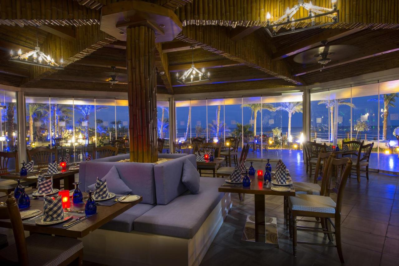 een restaurant met een bank, tafels en uitzicht op de stad bij Sunrise Montemare Resort -Grand Select in Sharm El Sheikh