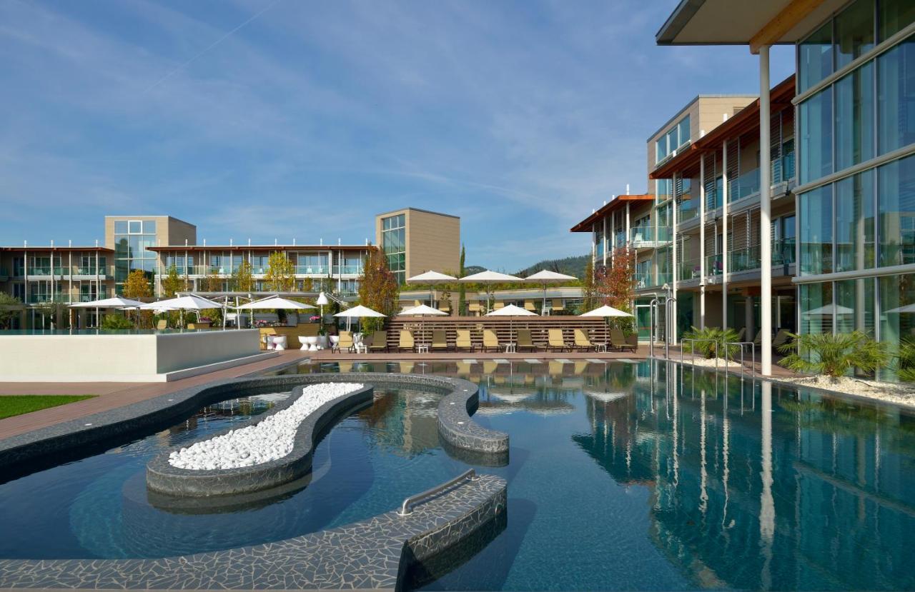 een zwembad in een gebouw met gebouwen bij Aqualux Hotel Spa Suite & Terme in Bardolino