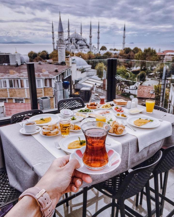 een tafel met borden vol eten en een kopje thee bij Sura Design Hotel & Suites in Istanbul