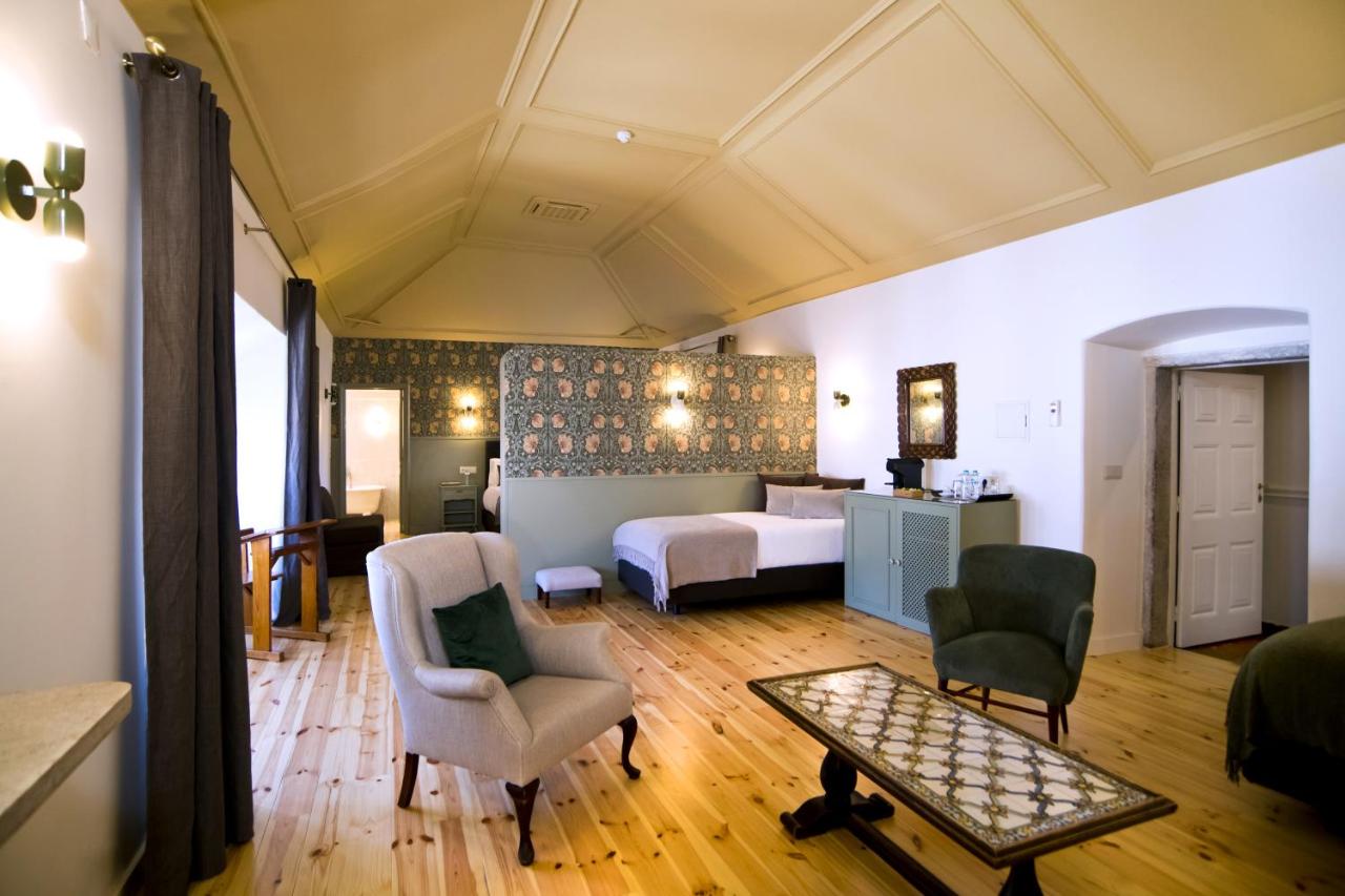 een slaapkamer met een bed en stoelen in een kamer bij York House Lisboa Hotel in Lissabon