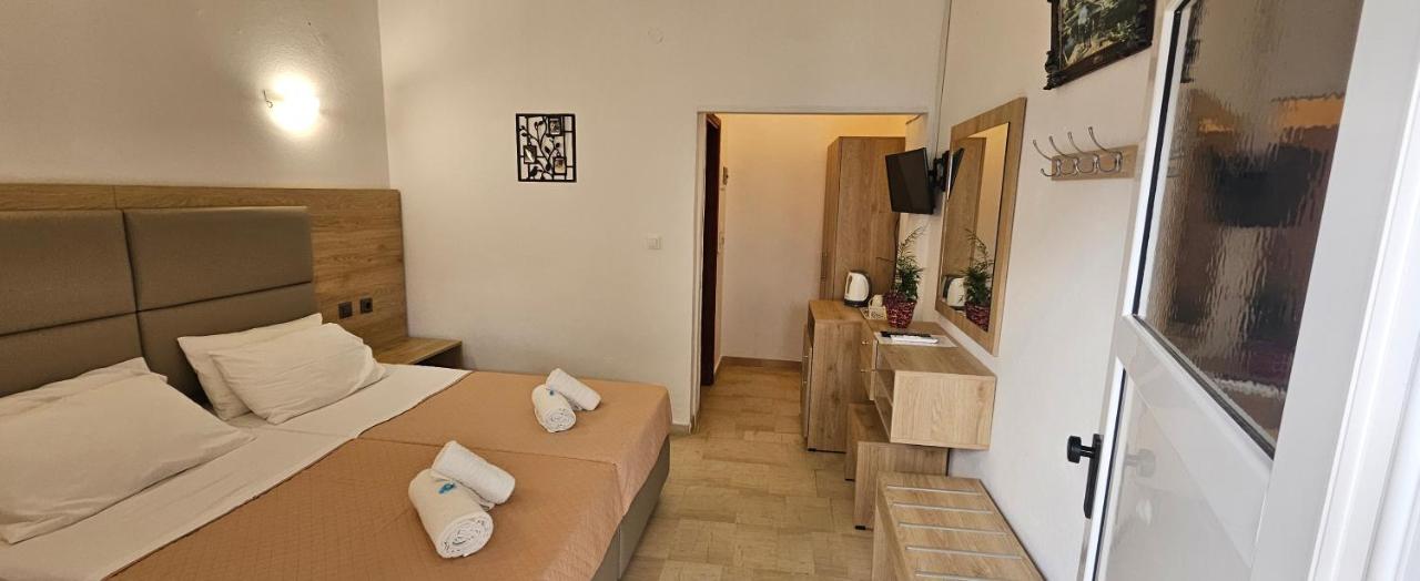 een kleine kamer met een bed en een televisie bij Pension Nychterida in Marathias