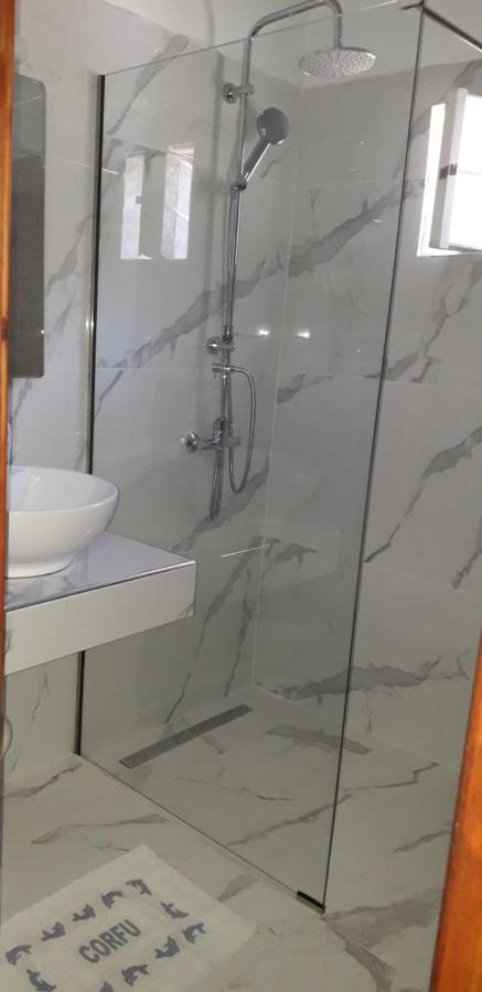 een badkamer met een douche en een wastafel bij Pension Nychterida in Marathias