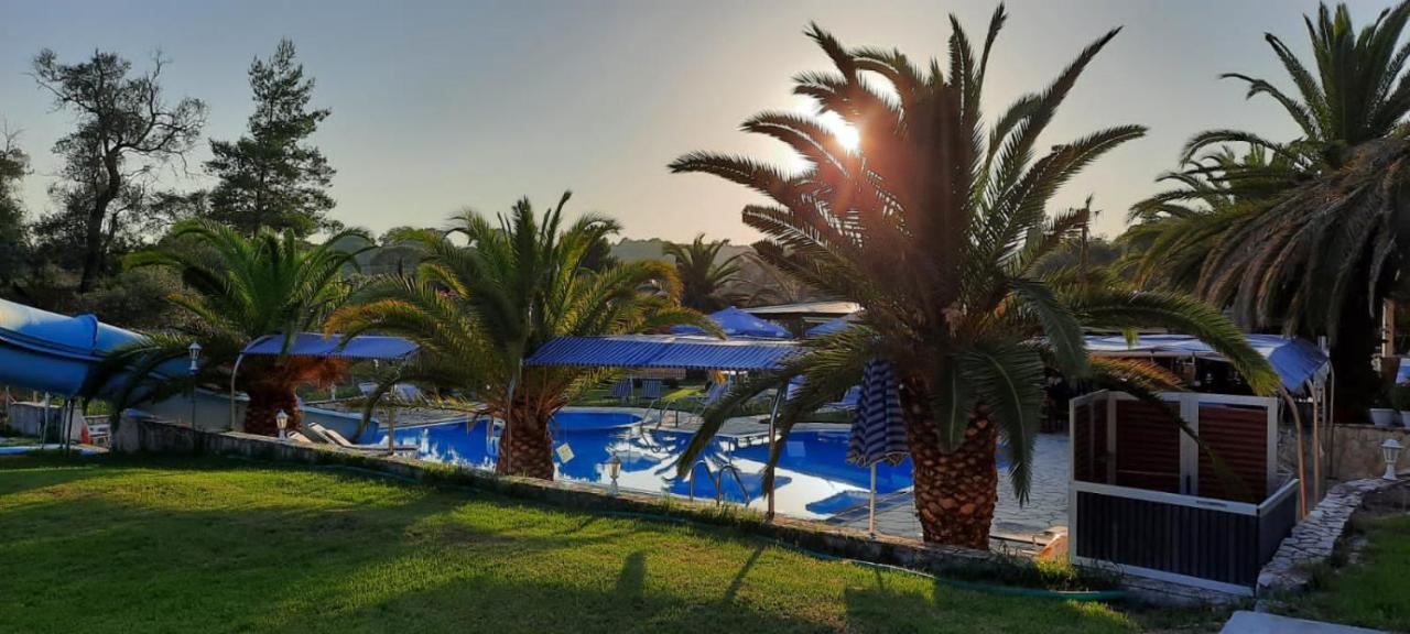een resort met een zwembad met palmbomen bij Pension Nychterida in Marathias