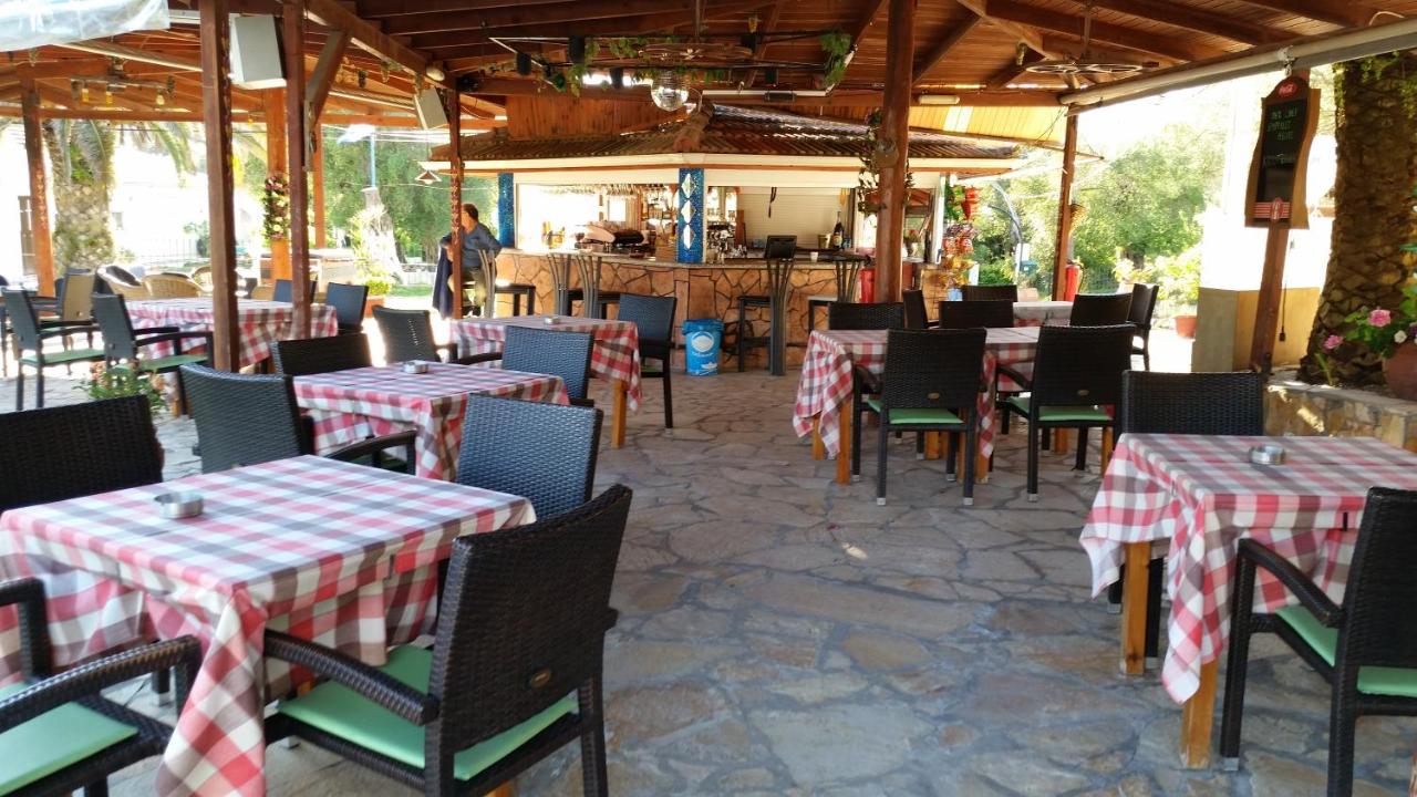 een restaurant met tafels en stoelen met rood-witte ruitjes. bij Pension Nychterida in Marathias