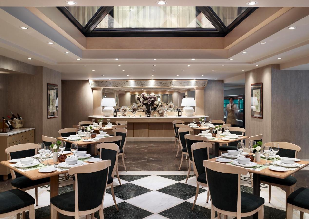 een restaurant met tafels en stoelen in een ruimte bij Athens Zafolia Hotel in Athene