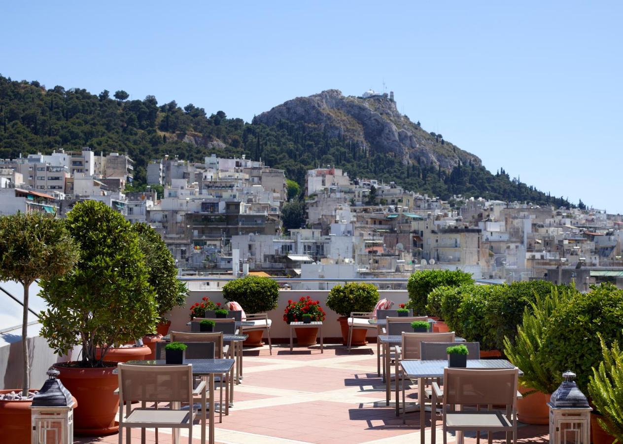 een rij tafels en stoelen bovenop een gebouw bij Athens Zafolia Hotel in Athene