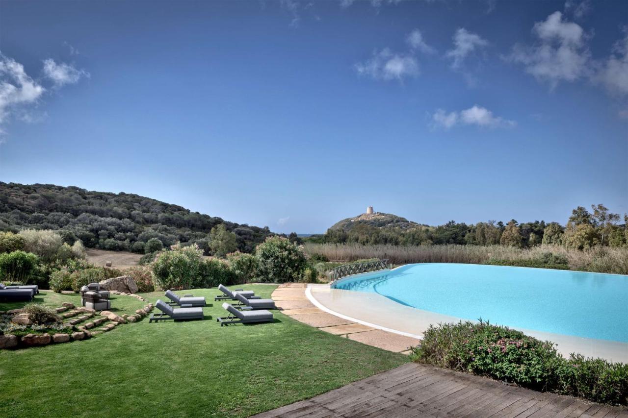 een zwembad met ligstoelen in een tuin bij Veridia Resort Sardinia, a member of Radisson Individuals in Chia