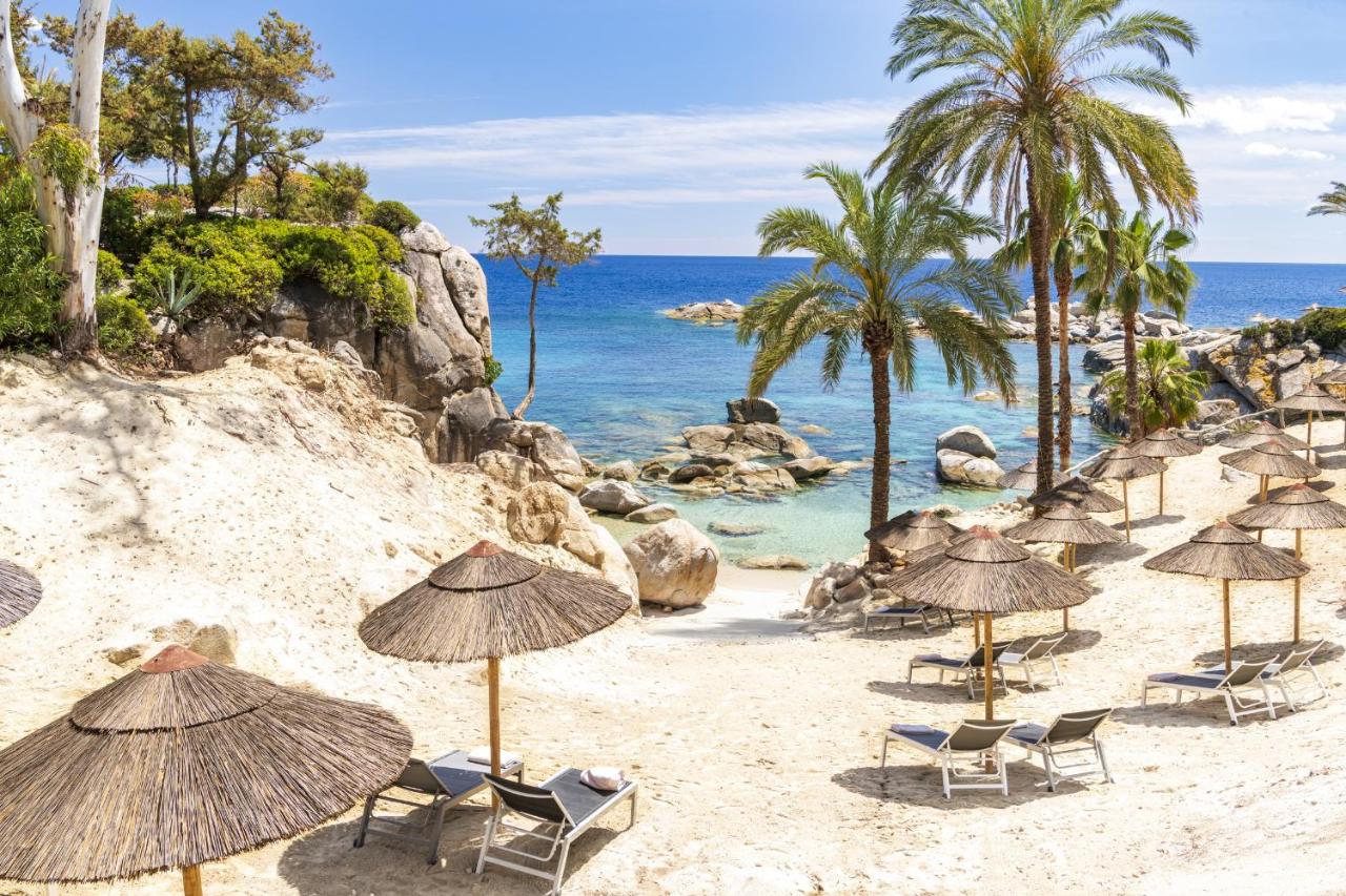 een groep stoelen en parasols op een strand bij Arbatax Park Resort - Dune by Falkensteiner in Àrbatax