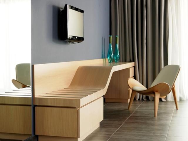 een bureau in een kamer met een tv aan de muur bij Tesoro Blu Hotel & Spa Adults Only in Skála Kefalonias