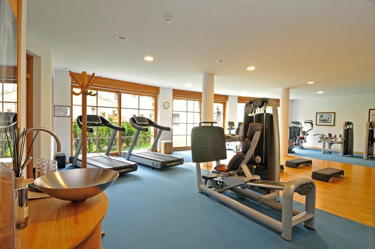 een sportschool met meerdere loopbanden en fitnessapparatuur bij Vitalhotel Dosses in Santa Cristina in Val Gardena
