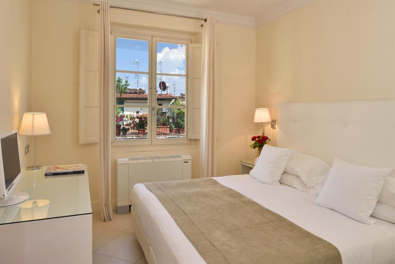 een witte slaapkamer met een bed en een raam bij Residenza Fiorentina in Florence
